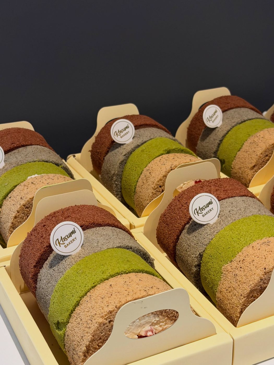 A box of assorted roll cake slices with Kasumi Bakery stickers
