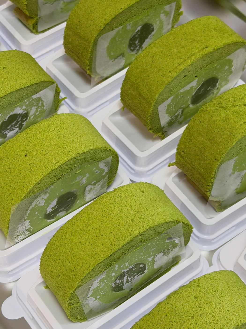Slices of matcha roll cake in their boxes